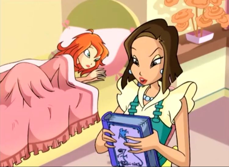 Bloom is laying in bed, the shelf with a flower is to the right of it