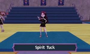 A photograph showing the player in ther cheerleading (or fearleading) uniform. They are in the school gym, standing on a blue mat and doing a fearleading move called 